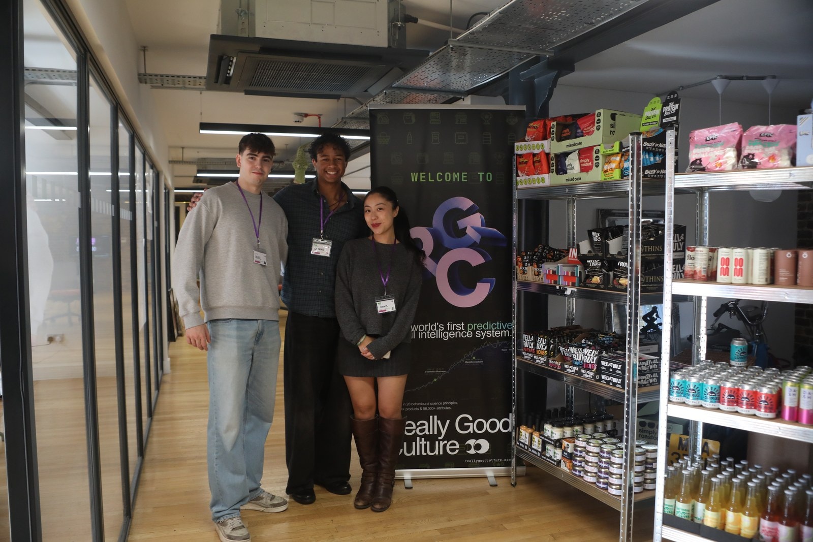Oriol, Gianni and Sophie Yau next to the welcome banner and The Shelf